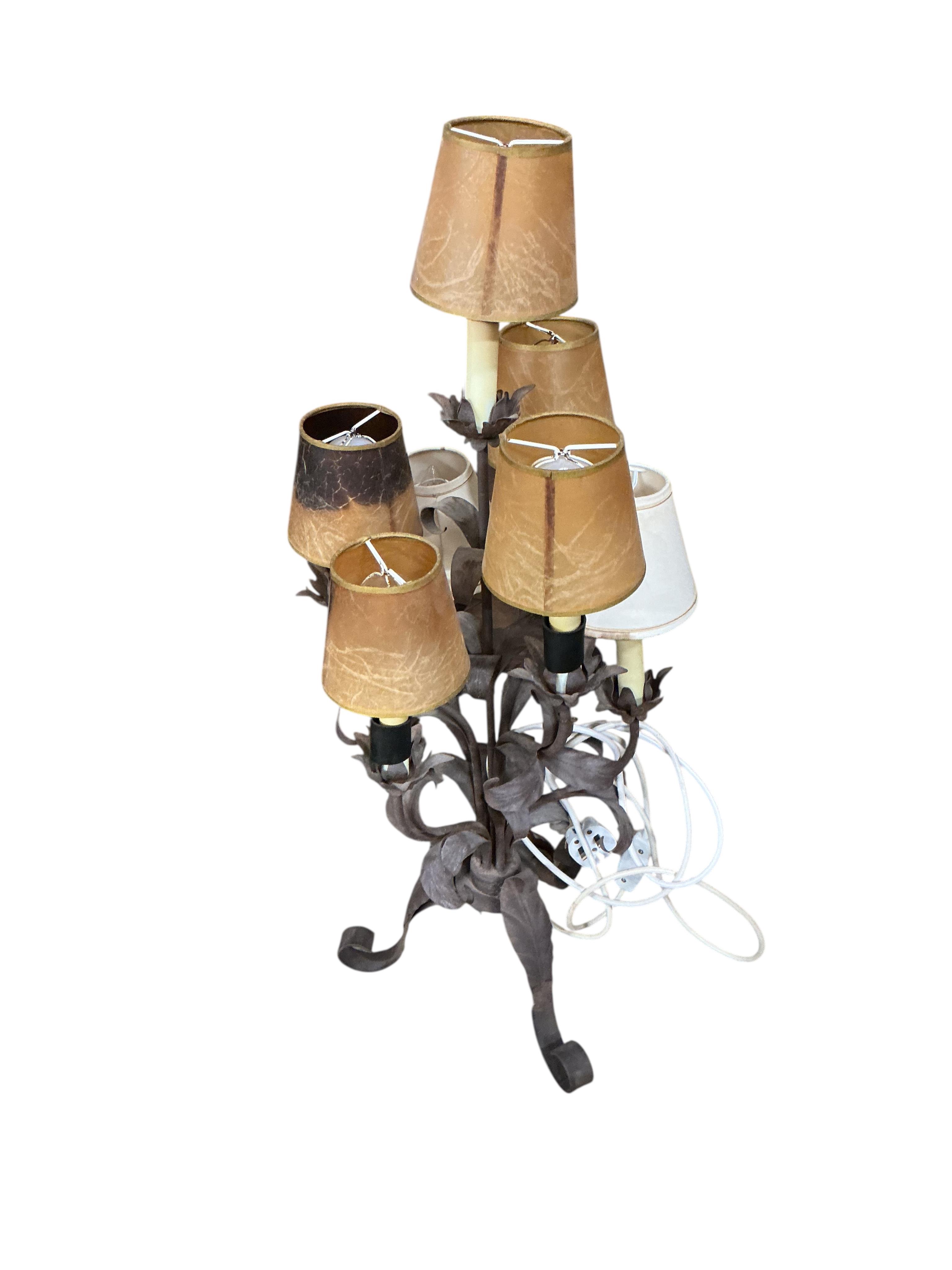 A pair of wrought and embossed four branch, five light candelabra, height 94cm